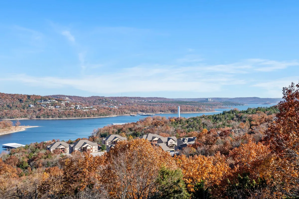 A breathtaking view of the lake with autumn foliage, distant hills, and a peaceful river, inviting activities such as boating, hiking, and nature photography.